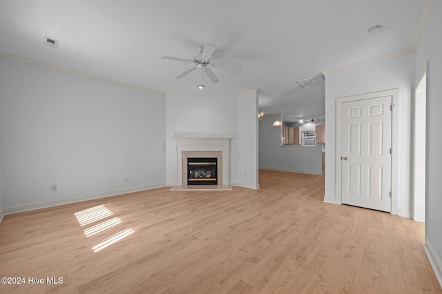 unfurnished living room featuring light hardwood / wood-style flooring, ceiling fan, crown molding, and a premium fireplace