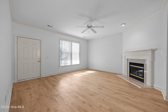 unfurnished living room featuring ceiling fan, crown molding, a high end fireplace, and light hardwood / wood-style flooring