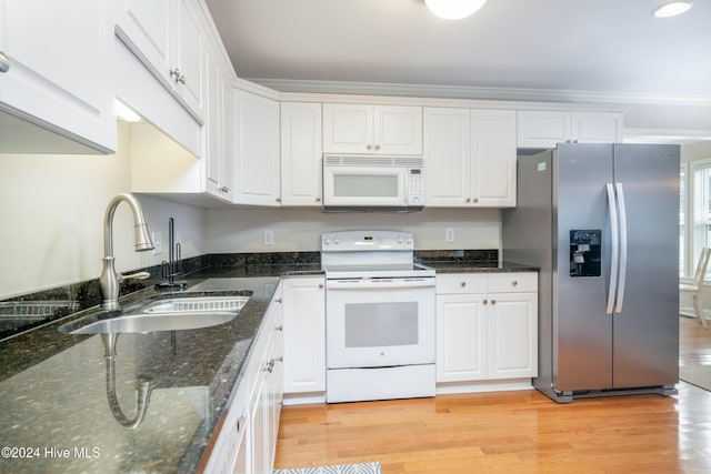 kitchen featuring white appliances, white cabinets, sink, dark stone countertops, and light wood-type flooring