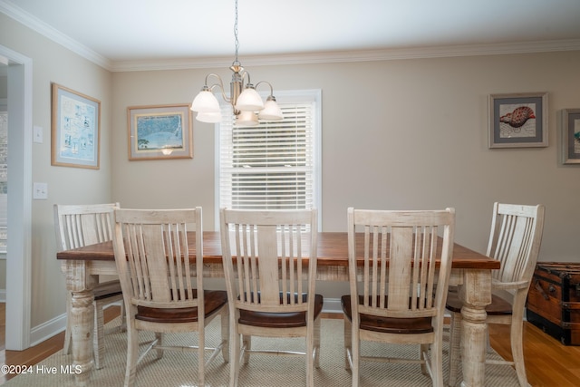 dining space with ornamental molding, a chandelier, and light wood-type flooring