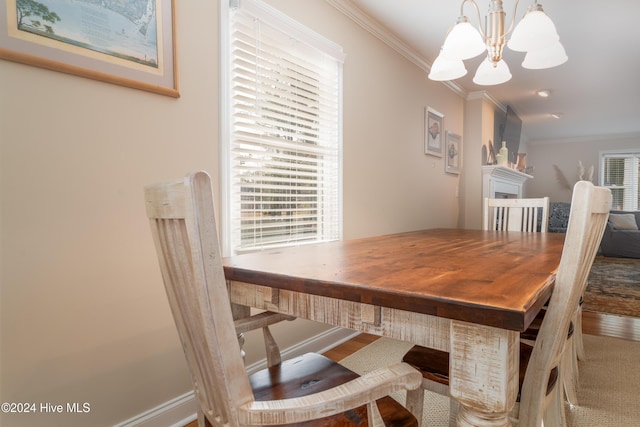 dining space featuring a fireplace, ornamental molding, and a notable chandelier