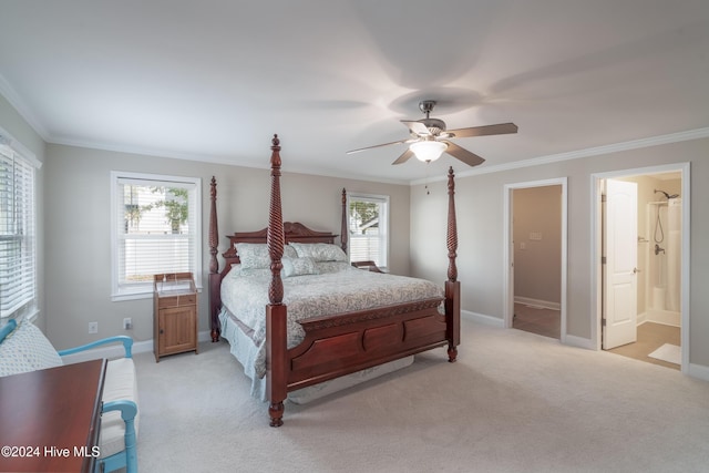 bedroom featuring multiple windows, ceiling fan, ensuite bath, and light colored carpet