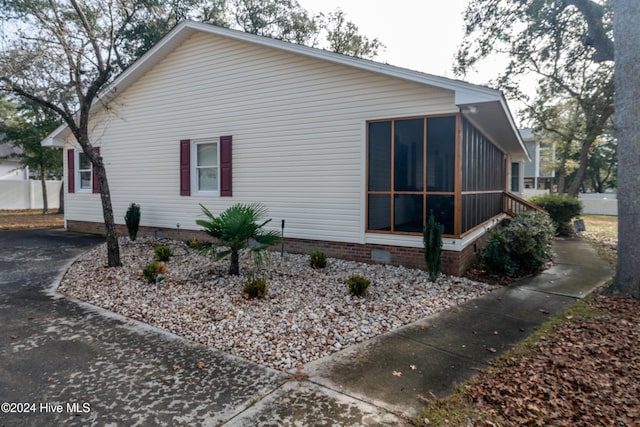 view of property exterior with a sunroom