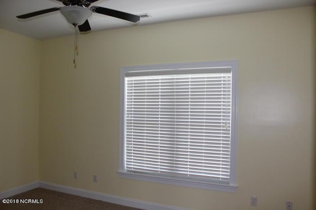 carpeted empty room featuring plenty of natural light and ceiling fan