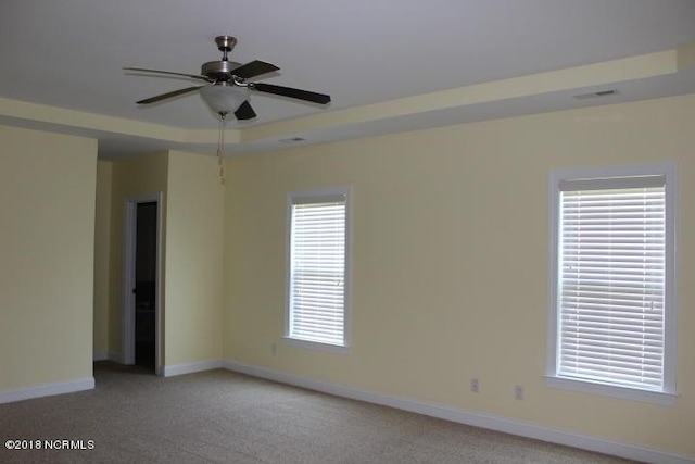 carpeted spare room with plenty of natural light and ceiling fan