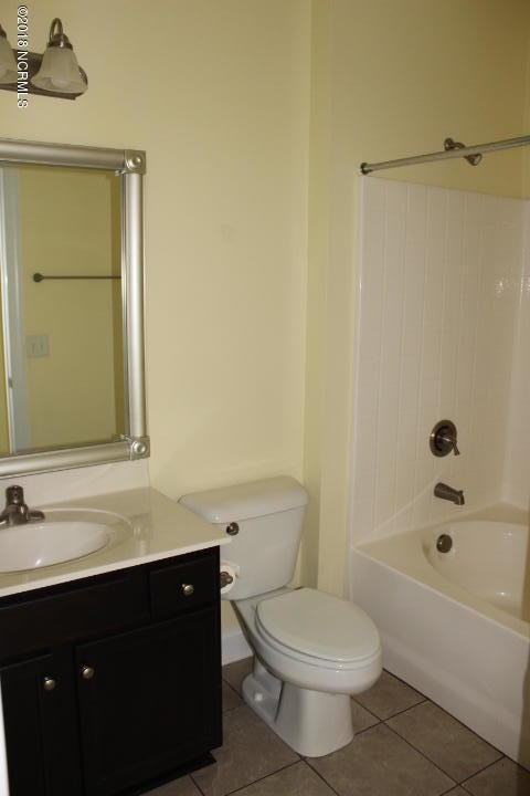 full bathroom with bathing tub / shower combination, tile patterned flooring, vanity, and toilet