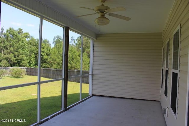 unfurnished sunroom with ceiling fan