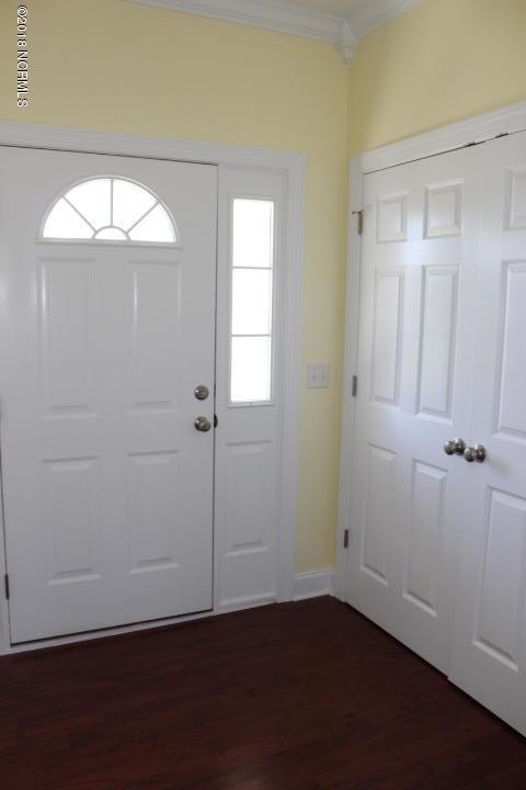 entryway with dark hardwood / wood-style floors and ornamental molding