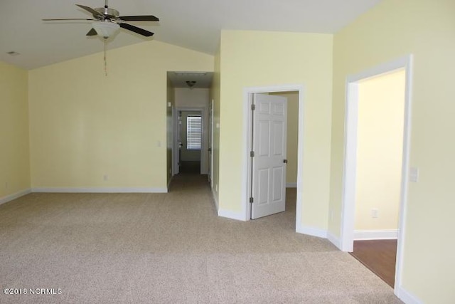 spare room with light colored carpet, vaulted ceiling, and ceiling fan