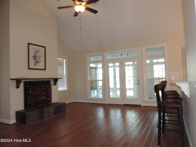 living room featuring dark hardwood / wood-style floors, high vaulted ceiling, and ceiling fan