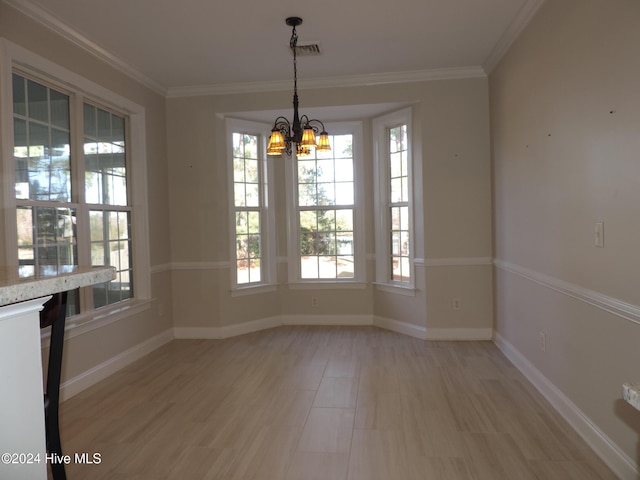 unfurnished dining area with crown molding, light hardwood / wood-style floors, and an inviting chandelier