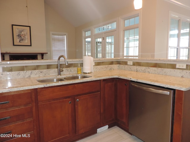 kitchen featuring dishwasher, light stone countertops, sink, and vaulted ceiling