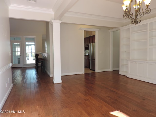 empty room with dark hardwood / wood-style flooring, ornamental molding, ornate columns, and a chandelier