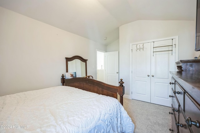 bedroom with light colored carpet, a closet, and lofted ceiling