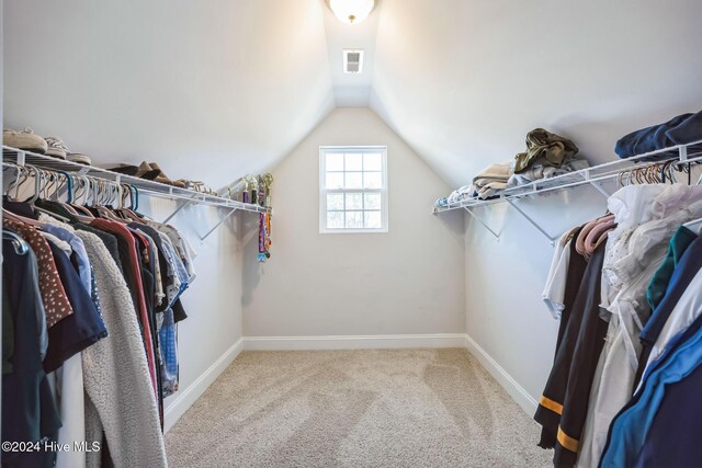 spacious closet featuring light colored carpet and vaulted ceiling