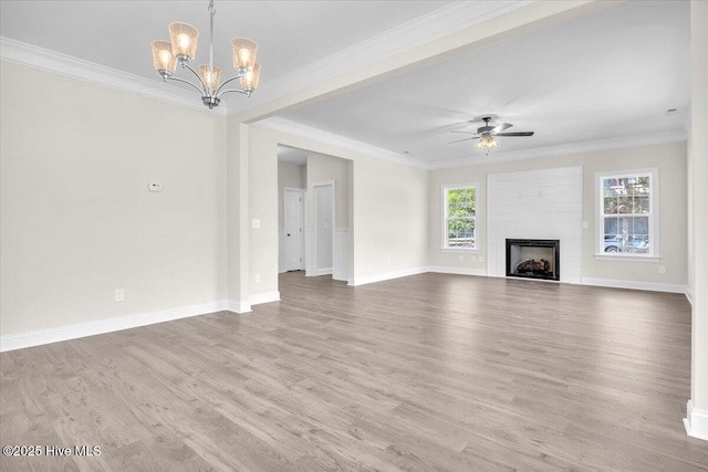 unfurnished living room featuring wood finished floors, ornamental molding, baseboards, a fireplace, and ceiling fan with notable chandelier