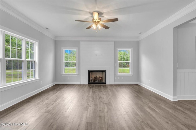 unfurnished living room with a fireplace, ceiling fan, crown molding, and dark wood-type flooring