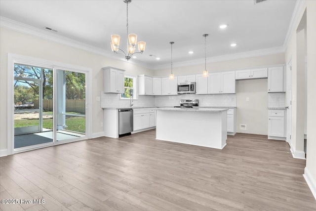 kitchen with crown molding, appliances with stainless steel finishes, and decorative backsplash