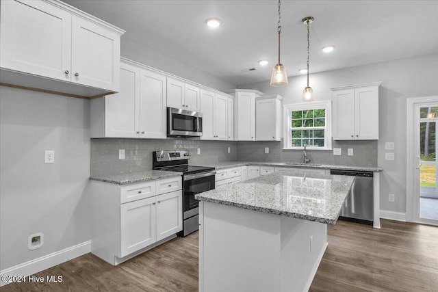 kitchen featuring sink, dark wood-type flooring, stainless steel appliances, a kitchen island, and white cabinets