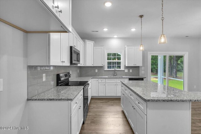 kitchen featuring a center island, sink, black range with electric cooktop, dark hardwood / wood-style flooring, and white cabinetry