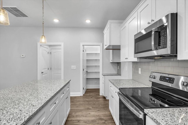 kitchen with hanging light fixtures, white cabinets, stainless steel appliances, and dark hardwood / wood-style floors