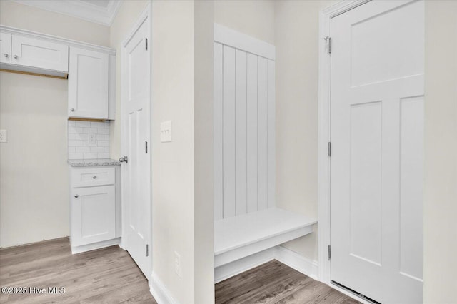 mudroom with baseboards, ornamental molding, and light wood-style floors