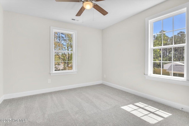 carpeted spare room featuring ceiling fan, baseboards, and visible vents