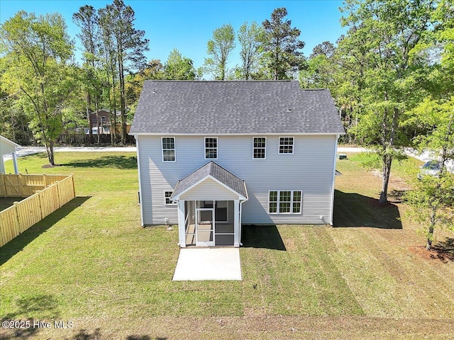 rear view of property featuring a patio area, a sunroom, fence, and a lawn