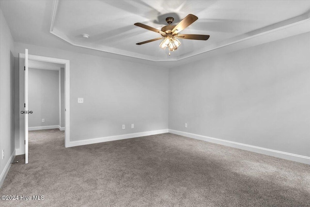 carpeted empty room with a tray ceiling and ceiling fan