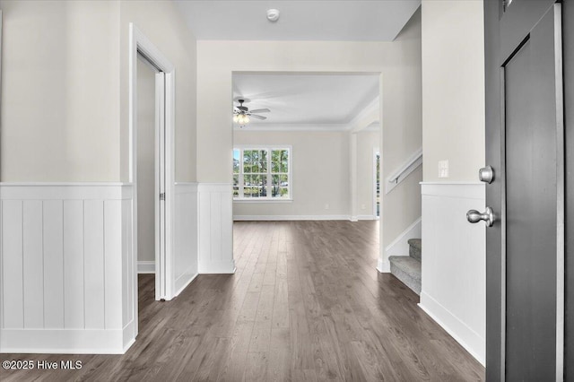hall with wood finished floors, a wainscoted wall, and stairway