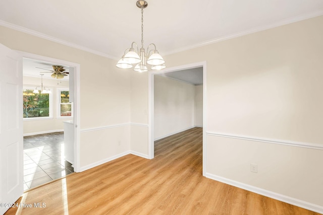 empty room with ceiling fan with notable chandelier, hardwood / wood-style flooring, and crown molding