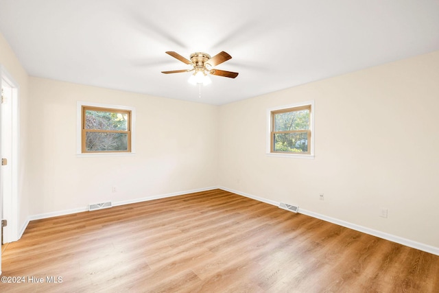 unfurnished room featuring ceiling fan, a wealth of natural light, and light hardwood / wood-style flooring