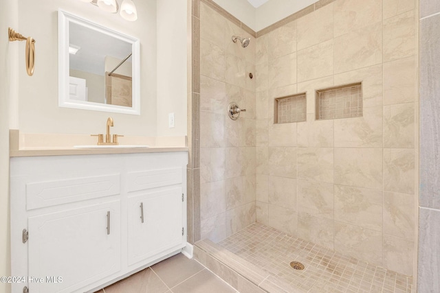 bathroom with a tile shower, tile patterned flooring, and vanity