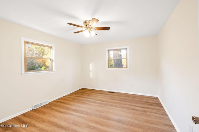 empty room with plenty of natural light, ceiling fan, and light hardwood / wood-style flooring