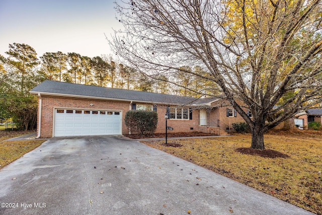 ranch-style home featuring a yard and a garage