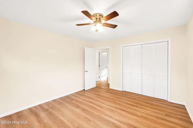 unfurnished bedroom featuring ceiling fan, a closet, and light wood-type flooring