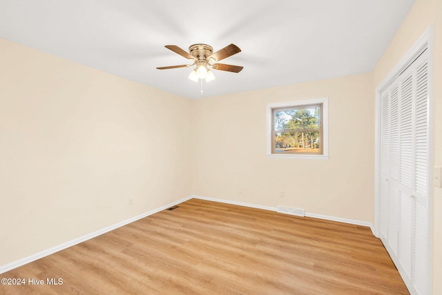 unfurnished bedroom featuring light wood-type flooring, a closet, and ceiling fan