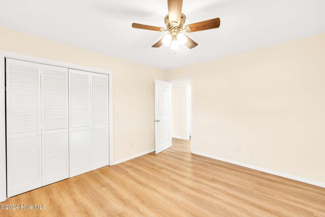 unfurnished bedroom featuring ceiling fan, a closet, and light hardwood / wood-style flooring