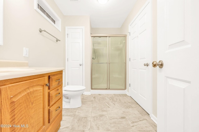 bathroom with vanity, a shower with shower door, and toilet