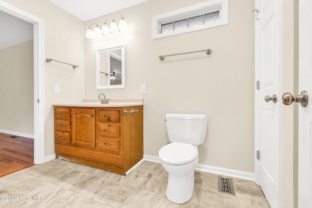 bathroom with hardwood / wood-style flooring, vanity, and toilet