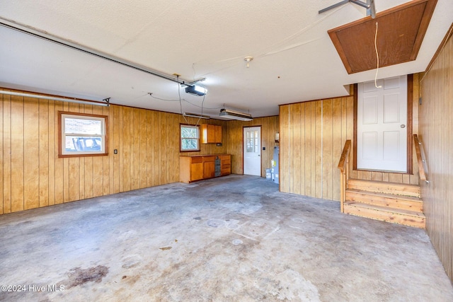 garage featuring wooden walls and a garage door opener