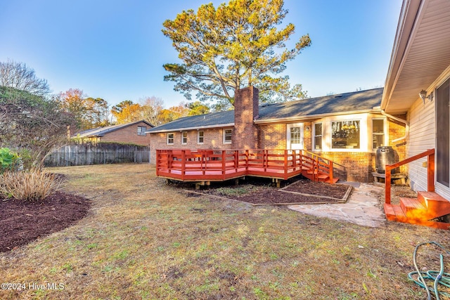 back of property with central air condition unit, a deck, and a lawn