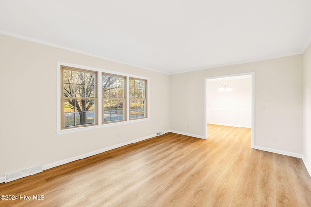 unfurnished room with light hardwood / wood-style flooring, a chandelier, and ornamental molding