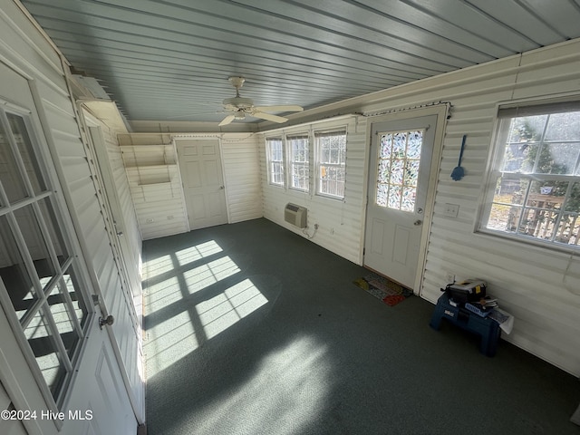 unfurnished sunroom with an AC wall unit and ceiling fan