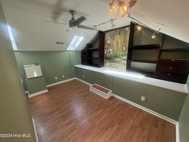 additional living space featuring hardwood / wood-style floors, lofted ceiling with skylight, and ceiling fan