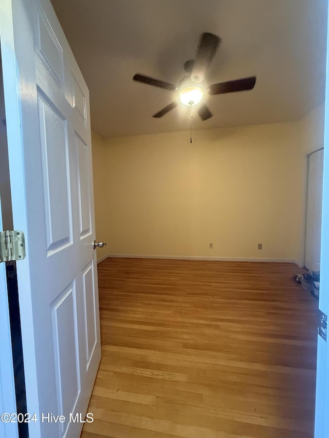 empty room with ceiling fan and light hardwood / wood-style floors