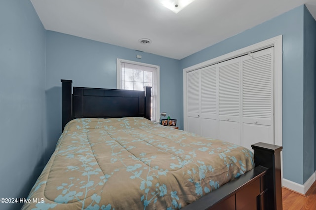 bedroom with light wood-type flooring and a closet