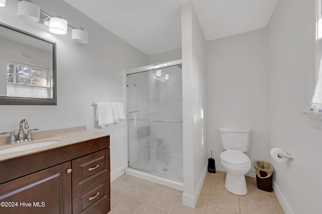 bathroom featuring tile patterned flooring, vanity, an enclosed shower, and toilet