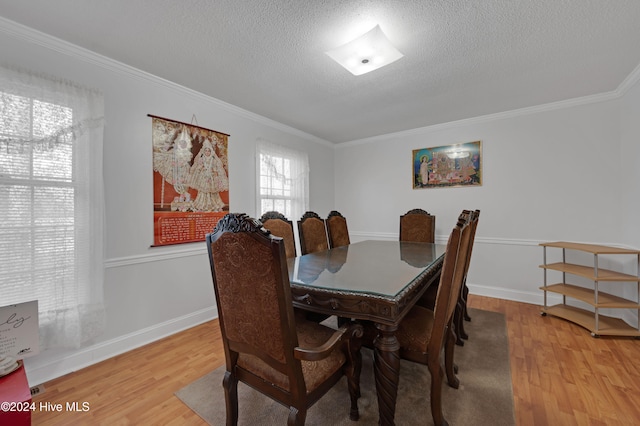 dining room featuring hardwood / wood-style floors, a textured ceiling, and crown molding