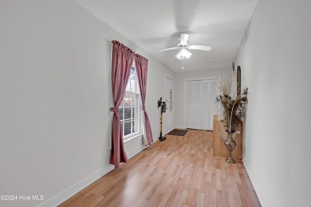 foyer entrance featuring ceiling fan, light hardwood / wood-style floors, and a textured ceiling